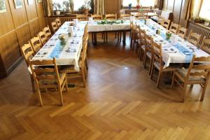 a large dining room with long tables and chairs at Brauerei und Gasthof Frischeisen in Kelheim