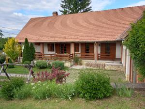a wooden house with a garden in front of it at Galambos Pincészet in Abaújszántó