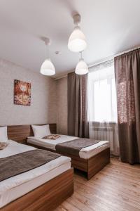 1 dormitorio con 2 camas y ventana en Matreshka Hotel, en Irkutsk