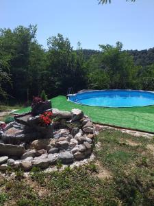 un patio trasero con piscina y un jardín de rocas en Katarina Doboj,Bušletić, en Busletić