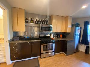 a kitchen with stainless steel appliances and brown cabinets at Alaskan Adventure Awaits! in Eagle River