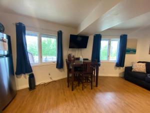 a living room with a table and blue curtains at Alaskan Adventure Awaits! in Eagle River