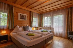 a bedroom with two beds in a room with wooden walls at Landhaus Hinteregg Apartment in Schladming