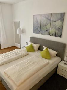 a bedroom with two beds with green pillows at Familienapartment An der Frauenkirche in Dresden