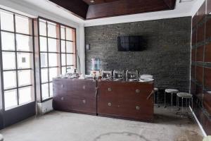a room with a counter and a tv on a brick wall at RedDoorz near Waterboom Lippo Cikarang in Cikarang
