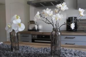 two glass vases with white flowers on a table at Gartenidyll in Satow