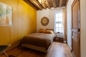 una camera da letto con un letto con pareti gialle e una finestra di Maison Juvénal des Ursins a Troyes