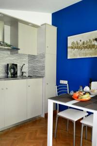 a kitchen with white cabinets and a blue wall at Apartamento en Villa con parking in Añorga-Lugariz