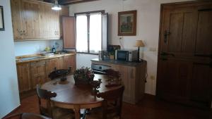 a kitchen with a wooden table and a microwave at VILLA ISABEL in Piloña