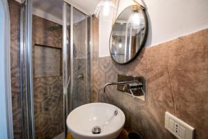 La salle de bains est pourvue d'un lavabo et d'une douche. dans l'établissement Trullo 11, à Alberobello