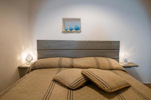 a bed with two pillows on it with two lamps at Trullo 11 in Alberobello
