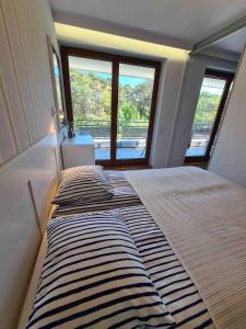two beds in a room with a large window at Apartament Jurata Deluxe in Jurata