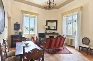 sala de estar con mesa, sillas y ventanas en 3bdrm luxury Apartment in Tuscan Villa,Private Estate, shared Swimmingpool en Florence