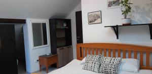 a bedroom with a bed with a wooden head board at Green Forest Apartments in Buşteni