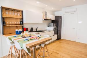 Una cocina con mesa y sillas y un refrigerador. en Calabona's promenade apartment, en Alghero 24 fotos más