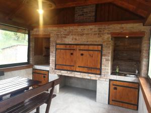 een keuken met houten kasten en een bank in een kamer bij Guest Accommodation Marko Kesić in Grabovac