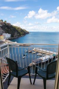 a balcony with two chairs and a view of a harbor at Coltur Suites in Sorrento