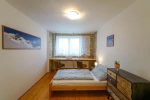 1 dormitorio con cama y escritorio. en Víkendový byt v Tatranskej Lomnici, en Tatranská Lomnica