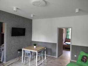 a living room with a table and chairs and a tv at Apartamenty Bulwar Nadmorski, Ustka in Ustka