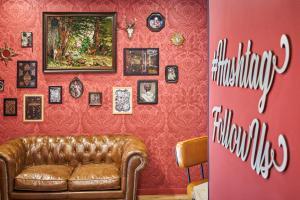 a living room with a couch and a red wall at Ibis Styles Paris Gare de l'Est Magenta in Paris