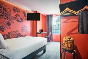 a hotel room with a bed and a backpack at Ibis Styles Paris Gare de l'Est Magenta in Paris