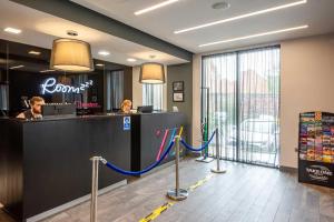 a lobby of a hotel with a reception counter and people at Roomzzz Chester City in Chester