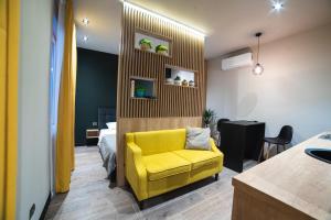 a yellow chair in a room with a bedroom at EVURI Apartments Petofi in Uzhhorod