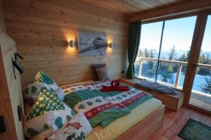 1 dormitorio con 1 cama en una cabaña de madera en Krummholzhütte en Haus im Ennstal