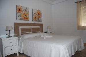 sypialnia z białym łóżkiem i 2 szafkami nocnymi w obiekcie APARTAMENTO LA TORNA w mieście Nerja