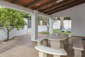 a patio with a table and benches and a tree at Casa Miguelin in Zahora