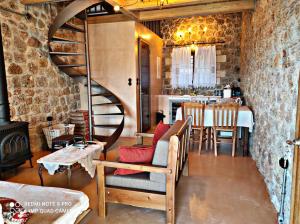 a living room with a spiral staircase and a table at Angelic in the mountains in Kaisárion