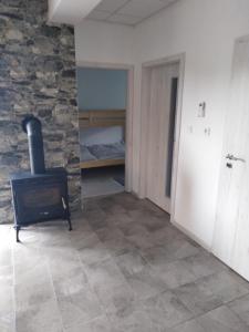 a room with a stone wall and a wood stove at Apartmány Vihorlat II in Kaluža