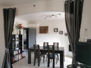 a dining room with a black table and chairs at Home Tranquille Dans la Cité du Mimosa - 2 étoiles - Axelle Loc'Appart in Mandelieu-la-Napoule