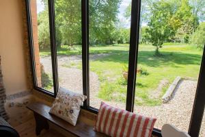 een raam met uitzicht op een tuin bij Le Chat Qui Perche. Gîte pour 6 personnes. in La Haute Duquerie