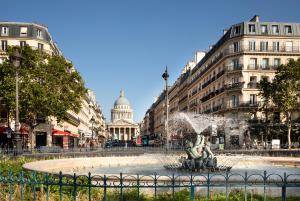 Una fuente en medio de una ciudad con un edificio. en Ibis Styles Paris Gare de l'Est Magenta, en París