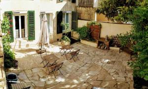 a patio with chairs and a umbrella in front of a building at Couette et Tartine in Chalon-sur-Saône