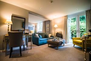 a living room with a blue couch and yellow chairs at Holdsworth House Hotel in Halifax