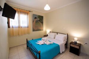 a bedroom with a bed and a flat screen tv at Delphinus Villa Nefeli in Agios Nikitas