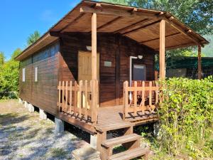 a wooden cabin with a porch and a deck at Barumi-Bungalow Michelangelo in Porlezza