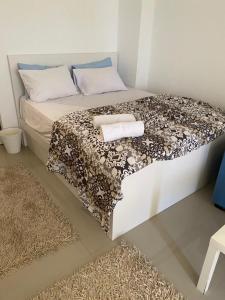 ein Schlafzimmer mit einem Bett mit einer Decke und einem Teppich in der Unterkunft G cribs B1F2 in Hurghada