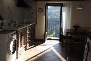 a kitchen with a washing machine and a door with a balcony at Casa La Soleá. Vistas al pueblo y la Sierra in Bubión
