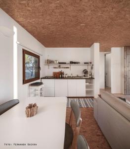 a kitchen and living room with a table and a couch at Monte Velho Retreat Centre in Aljezur