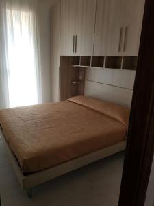 um quarto com uma cama, uma janela e armários em Blu Baita em La Maddalena