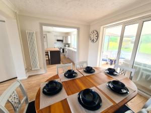uma sala de jantar com mesa e cadeiras e uma cozinha em Beach Chalet, Little Walsingham Norfolk em Little Walsingham
