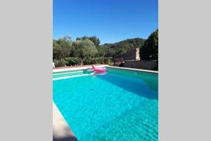 a swimming pool with a red boat in the water at Gîte Le Petit Jas in Villeneuve