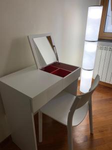 キアーヴァリにあるCasa Entella by Vacanze in Chiavariの白いデスク(鏡、椅子付)