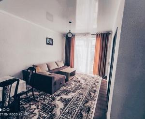a living room with a couch and a rug at Коттедж в ЦО Париж in Chok-Tal +17 photos