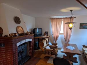 a living room with a brick fireplace and a table at Village Home - Kuca u prirodi in Tešanj