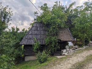 a small house with a black roof in a field at Village Home - Kuca u prirodi in Tešanj
