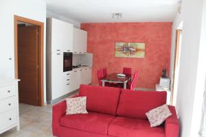 un soggiorno con divano rosso e tavolo di Paradiso sul Lago Maggiore a Baveno